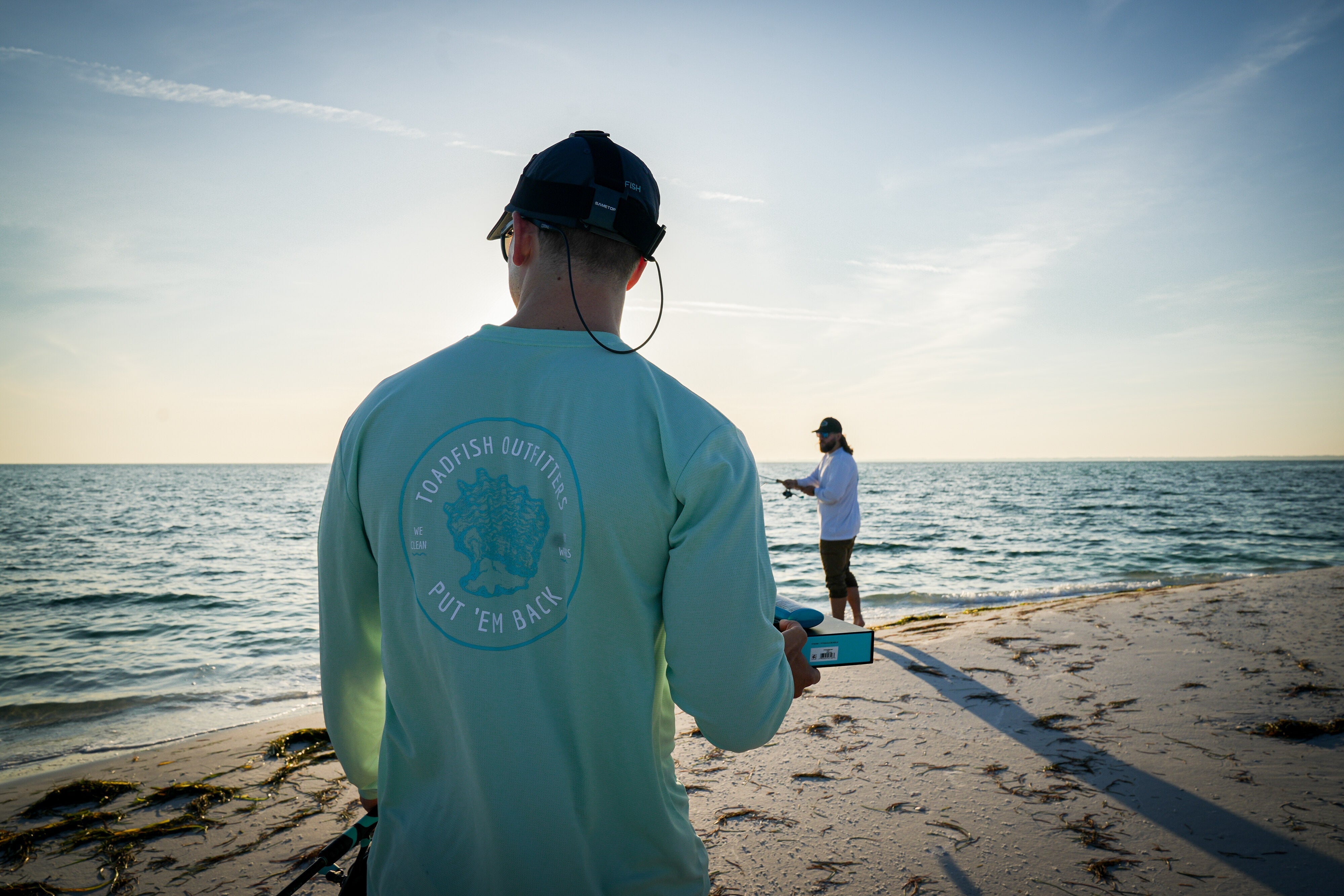 a man is on the beach with his performance longsleeve