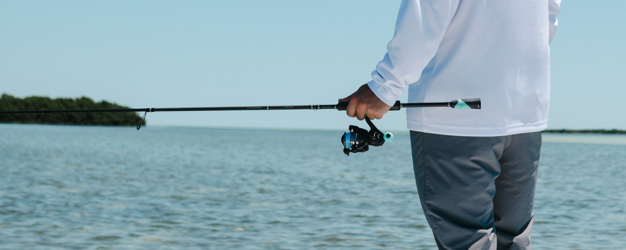 a man is holding a carbon elite II spinning combo from Toadfish