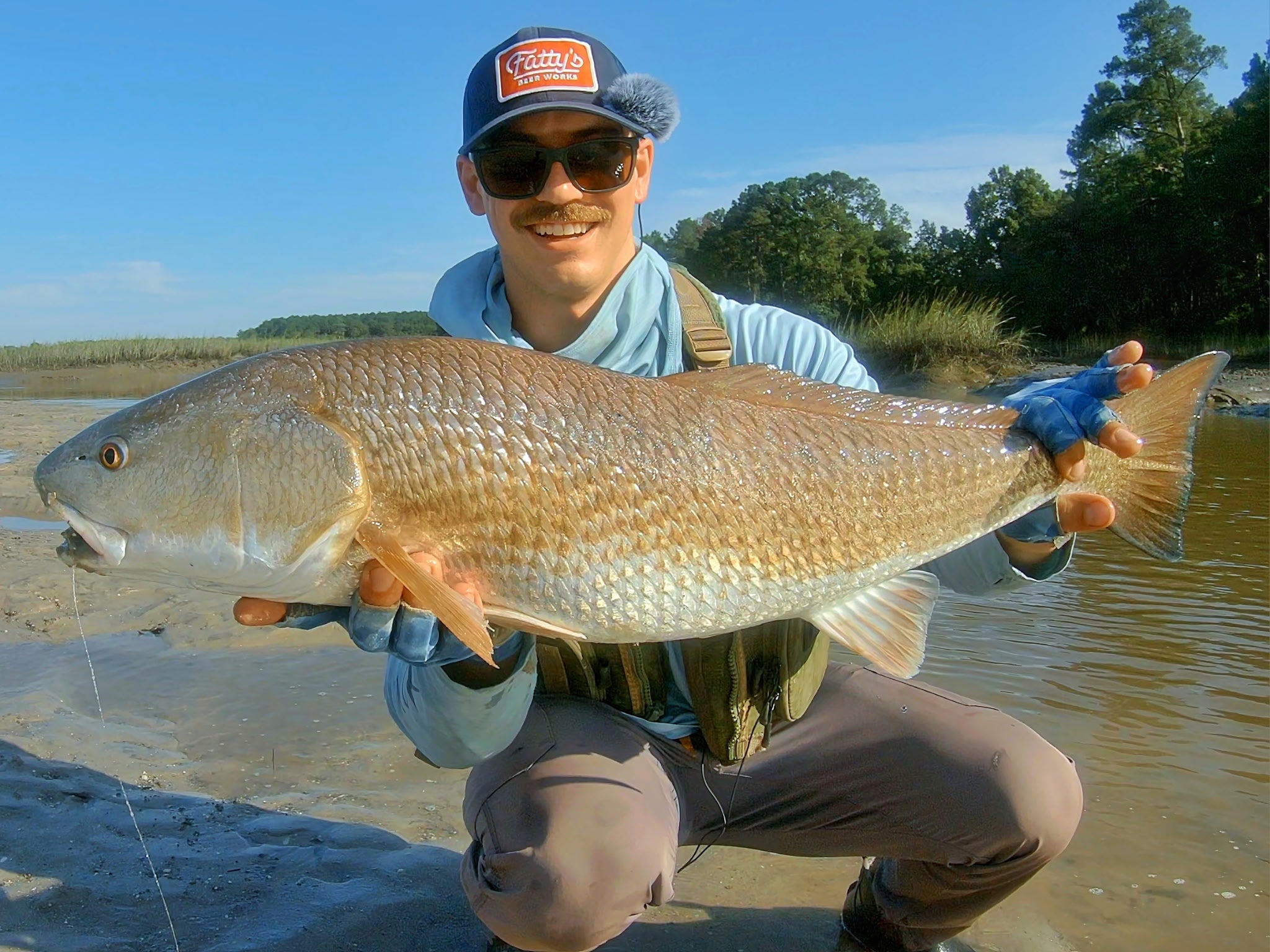 Toadfish Ambassador Christian Conley is shown holding a large shall-water redfish that was caught on the Carbon Elite II combo