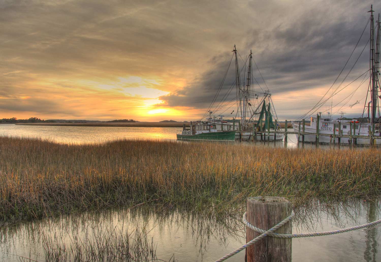 a photo shows crosbys fish and shrimp as the sun is setting over the folly river