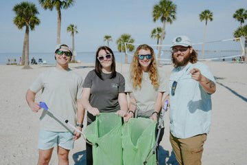 A group of people are at a beach clean-up