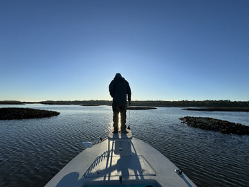 Man on the casting platform of a flats boat